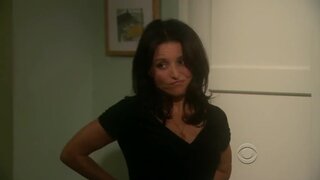 Julia Louis-Dreyfus taking off her bra from under her shirt