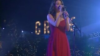 Emmy Rossum singing in a red dress on Grove Christmas