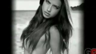 Adriana Lima with hair and sand barely covering her boobs